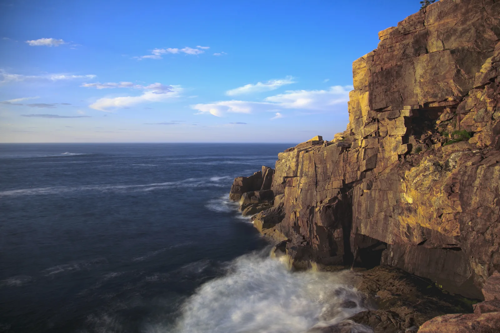 Die Granitwand des Otter Cliff über dem Atlantik, unten schäumt die Brandung an den Felsen