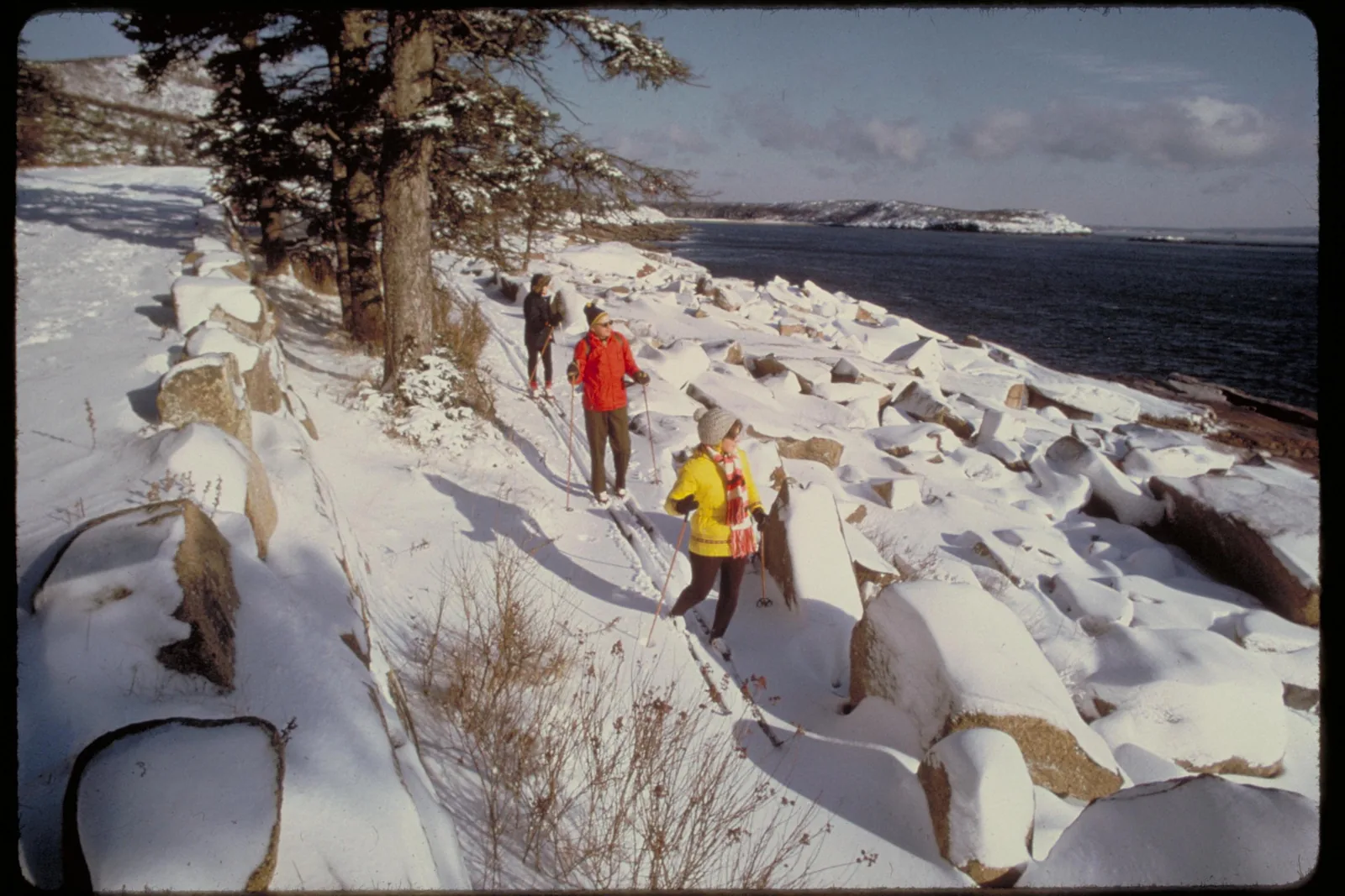 Historische Aufnahme: Langläufer zwischen verschneiten Granitblöcken an der Küste des Acadia-Nationalparks