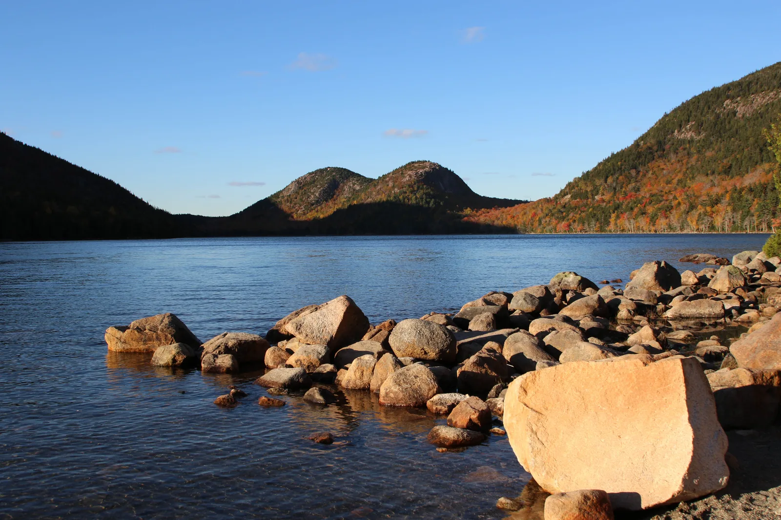 Jordan Pond im Abendlicht, am Ufer rosa Granitblöcke, dahinter die beiden runden Gipfel der Bubbles
