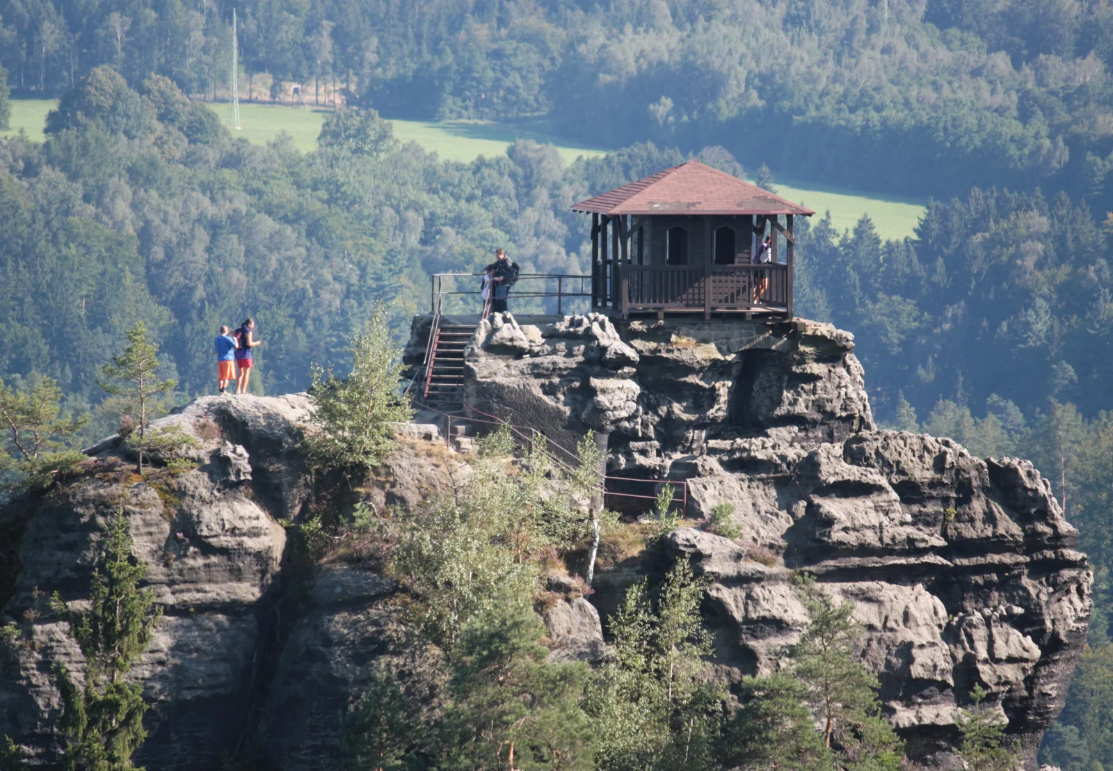Der Marienfelsen bei Jetřichovice in der Böhmischen Schweiz mit seiner hölzernen Aussichtshütte auf dem Felskopf, davor Wanderer auf der Plattform