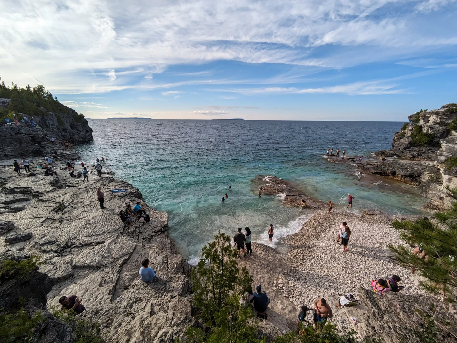 Indian Head Cove: türkises Wasser in einer Bucht zwischen weißen Kalksteinterrassen, auf den Felsen sitzen und schwimmen zahlreiche Besucher