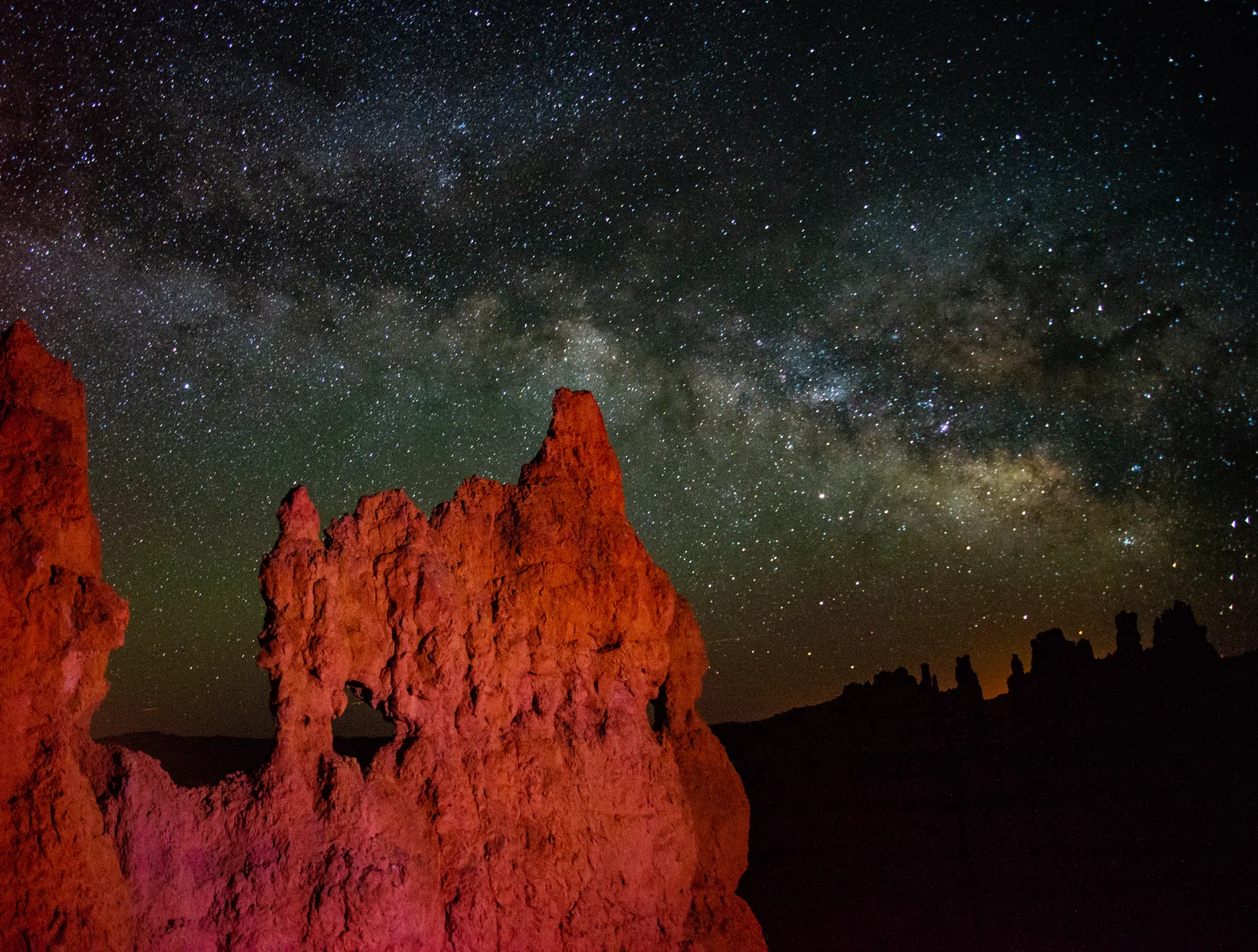 Milchstraße über einem angestrahlten Hoodoo am Navajo Trail im Bryce-Canyon-Nationalpark