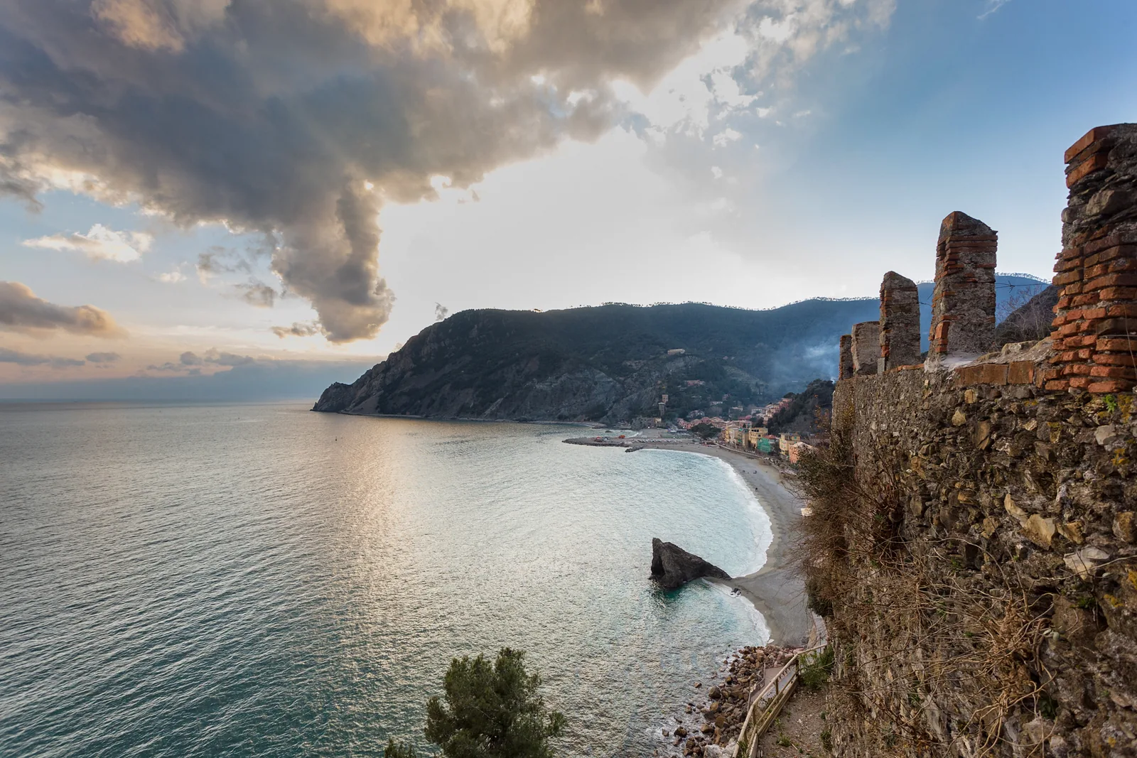 Blick von Monterosso al Mare im Nationalpark Cinque Terre über die Bucht auf Punta Mesco, rechts Mauerreste