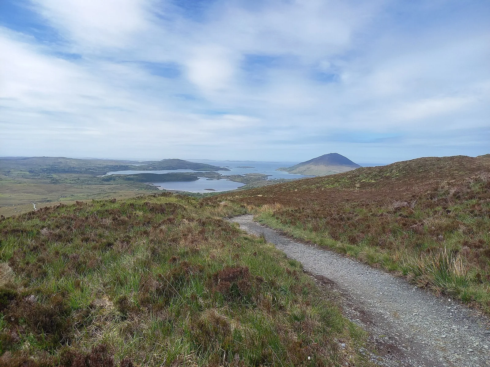 Blick vom Diamond Hill im Connemara-Nationalpark über grüne Hänge, Seen und Hügel an einem sonnigen Tag
