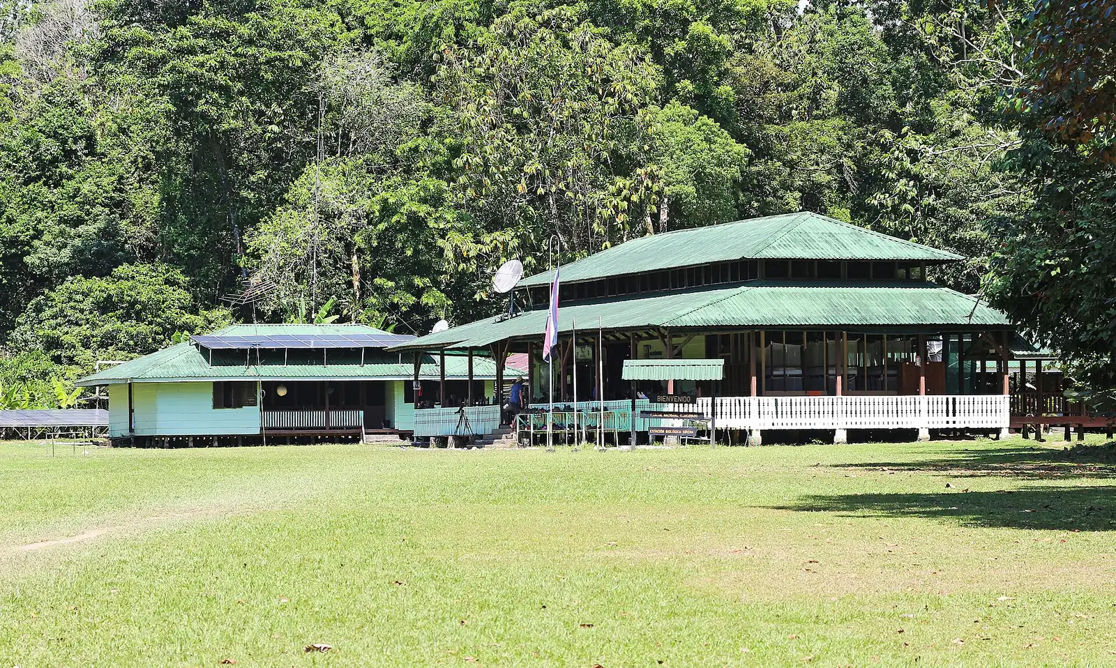 Die hölzerne Rangerstation Sirena im Corcovado-Nationalpark mit grünem Dach auf einer Wiese vor dichtem Regenwald