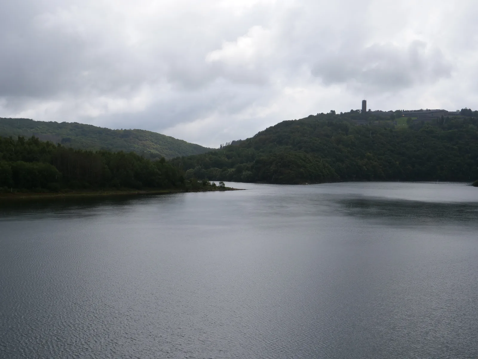 Der Urftsee, dahinter auf dem Höhenrücken der Turm von Vogelsang