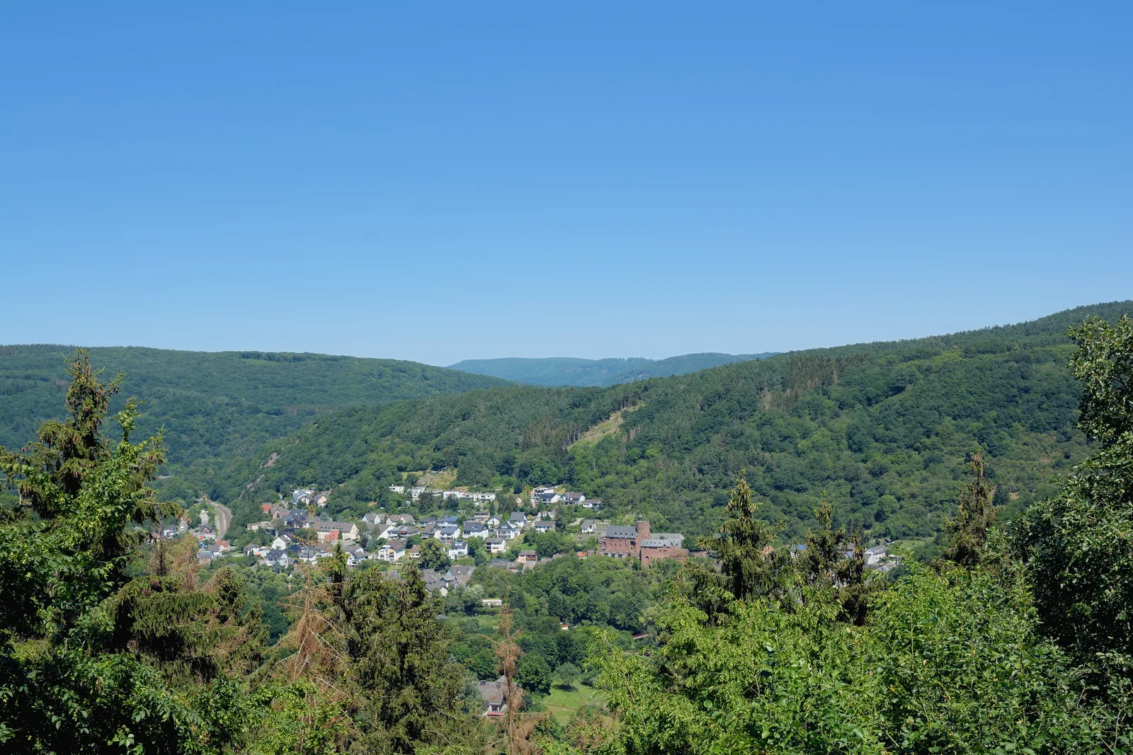 Blick über bewaldete Höhen auf das Dorf Heimbach im Tal der Rur