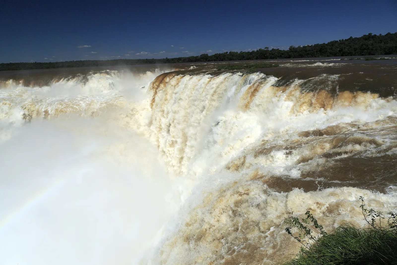 Braune Wassermassen stürzen in die Südostecke der Garganta del Diablo, Gischt verdeckt den Grund der Schlucht