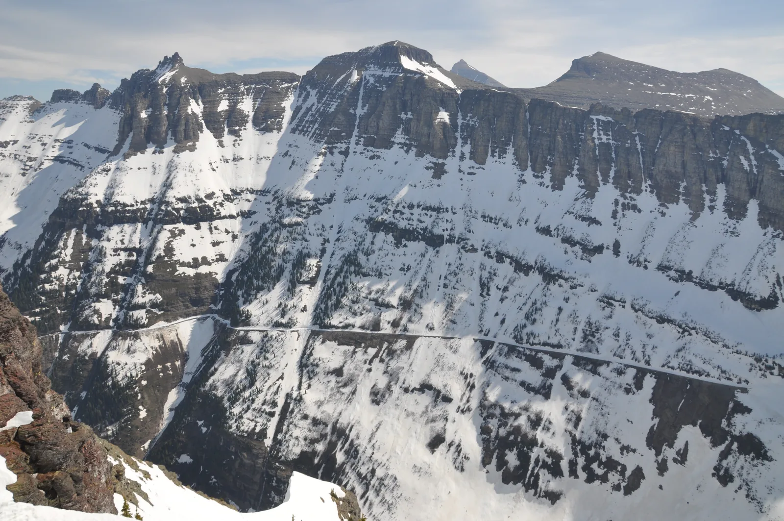 Der Highline Trail als schmales Band an der schneegefleckten Felswand der Garden Wall