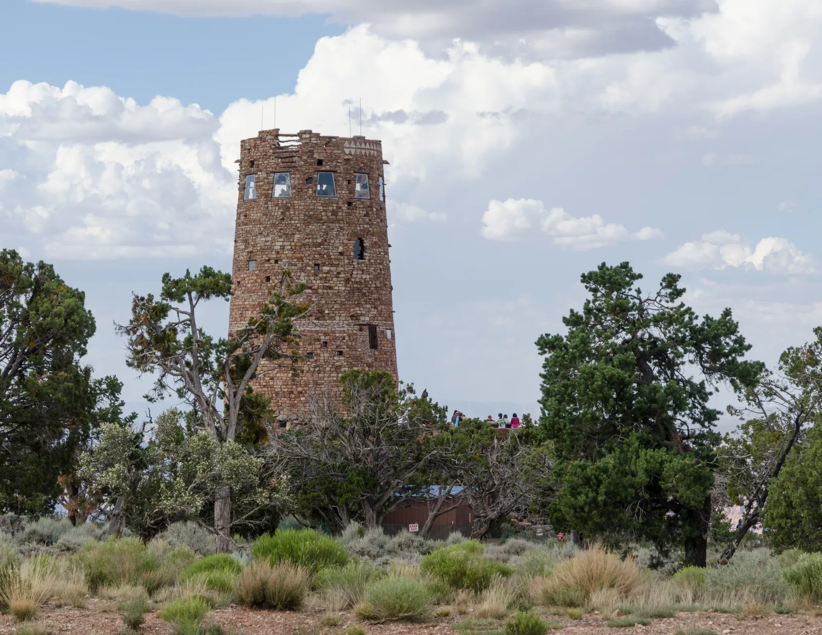Der steinerne Desert View Watchtower ragt über Wacholderbüsche am Ostrand des Grand Canyon