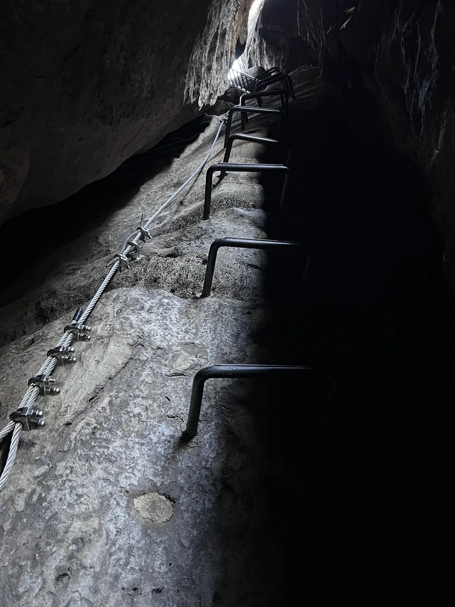 Eisenbügel und Drahtseil im engen Felsspalt des oberen Abschnitts der Häntzschelstiege in den Affensteinen