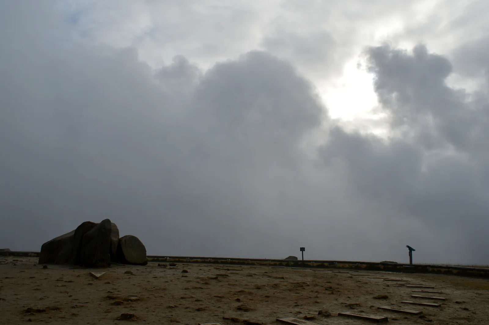 Das kahle Gipfelplateau des Brockens unter aufreißender Wolkendecke