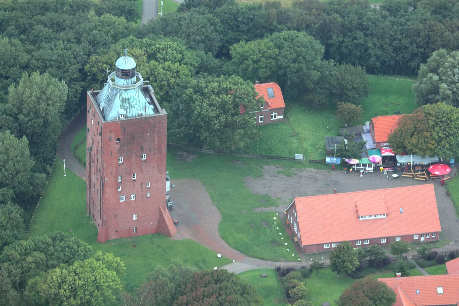 Der wuchtige Backsteinturm von Neuwerk aus der Luft, umgeben von den roten Dächern der Inselhäuser