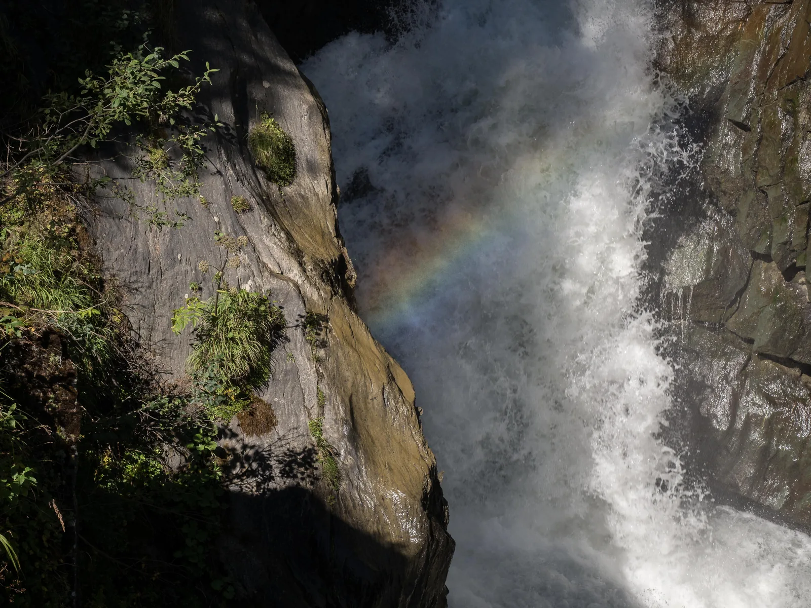 Die Umbalfälle stürzen durch eine enge Felsschlucht, im Sprühnebel ein Regenbogen