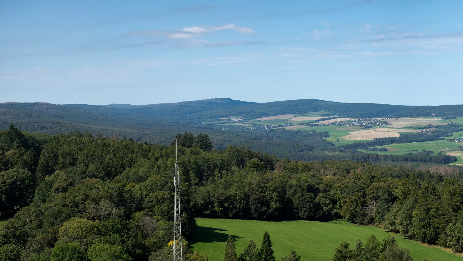 Blick von der Wildenburg über bewaldete Höhenzüge hinüber zum langgestreckten Rücken des Erbeskopfs