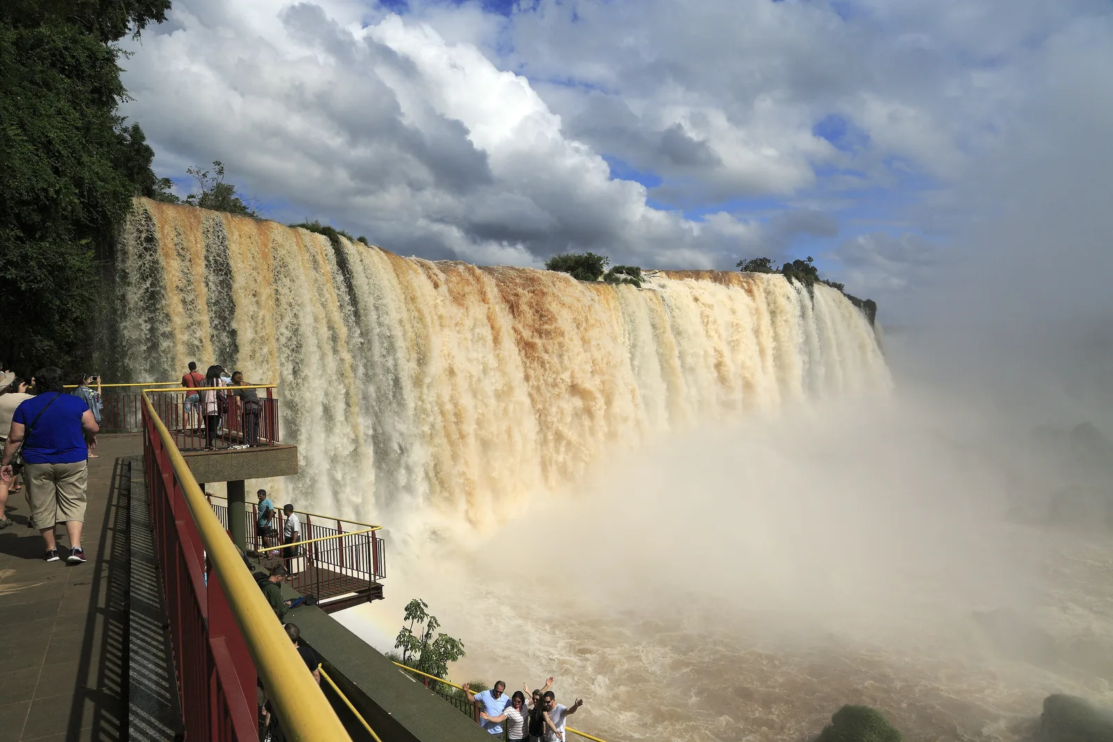 Vom Aussichtsturm am Salto Floriano im Iguaçu-Nationalpark blickt man auf eine breite Wasserwand, auf den Plattformen stehen Besucher