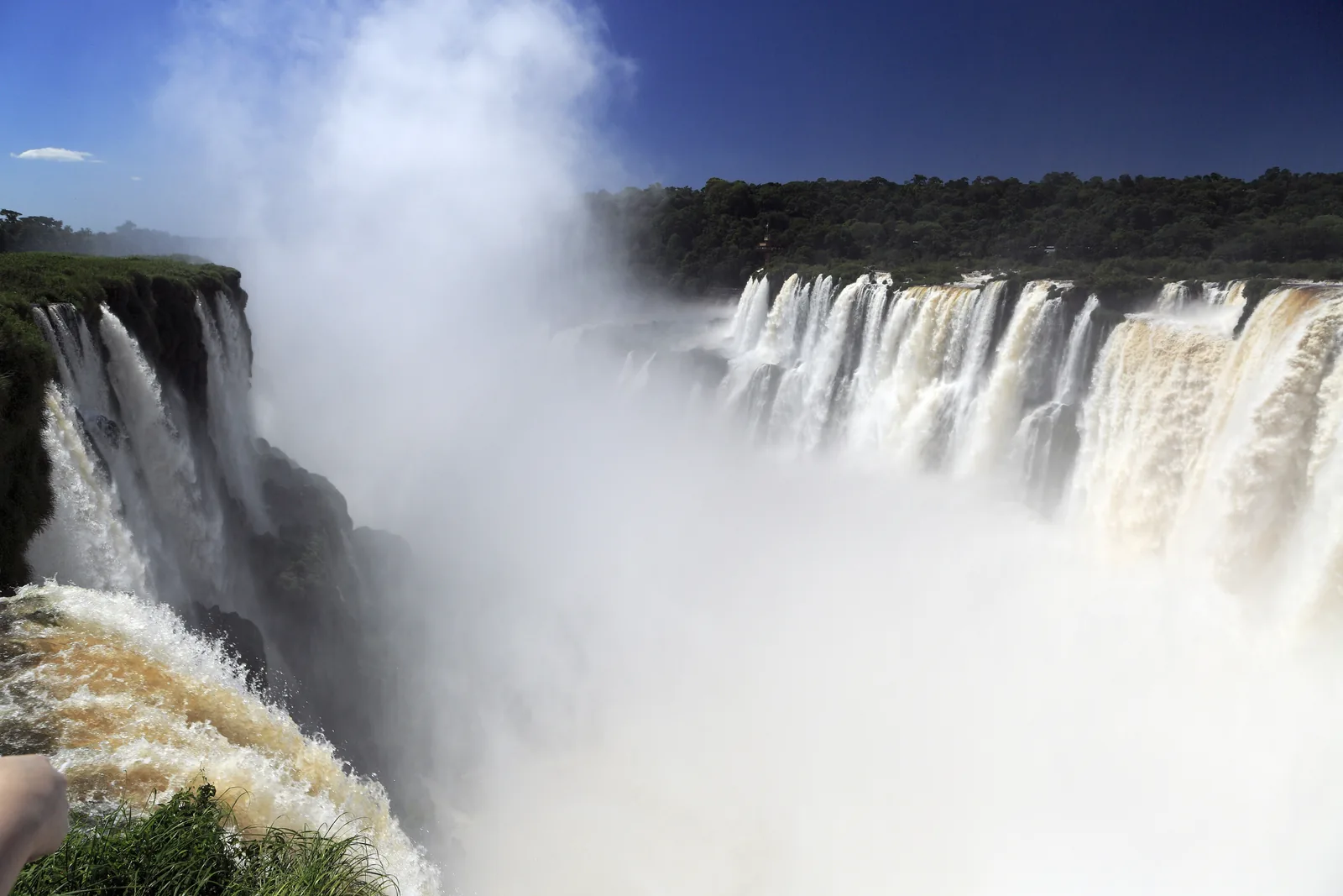 Gischt steigt aus der hufeisenförmigen Garganta del Diablo im Iguazú-Nationalpark, rechts stürzen breite weiße Wasserfälle über die Kante