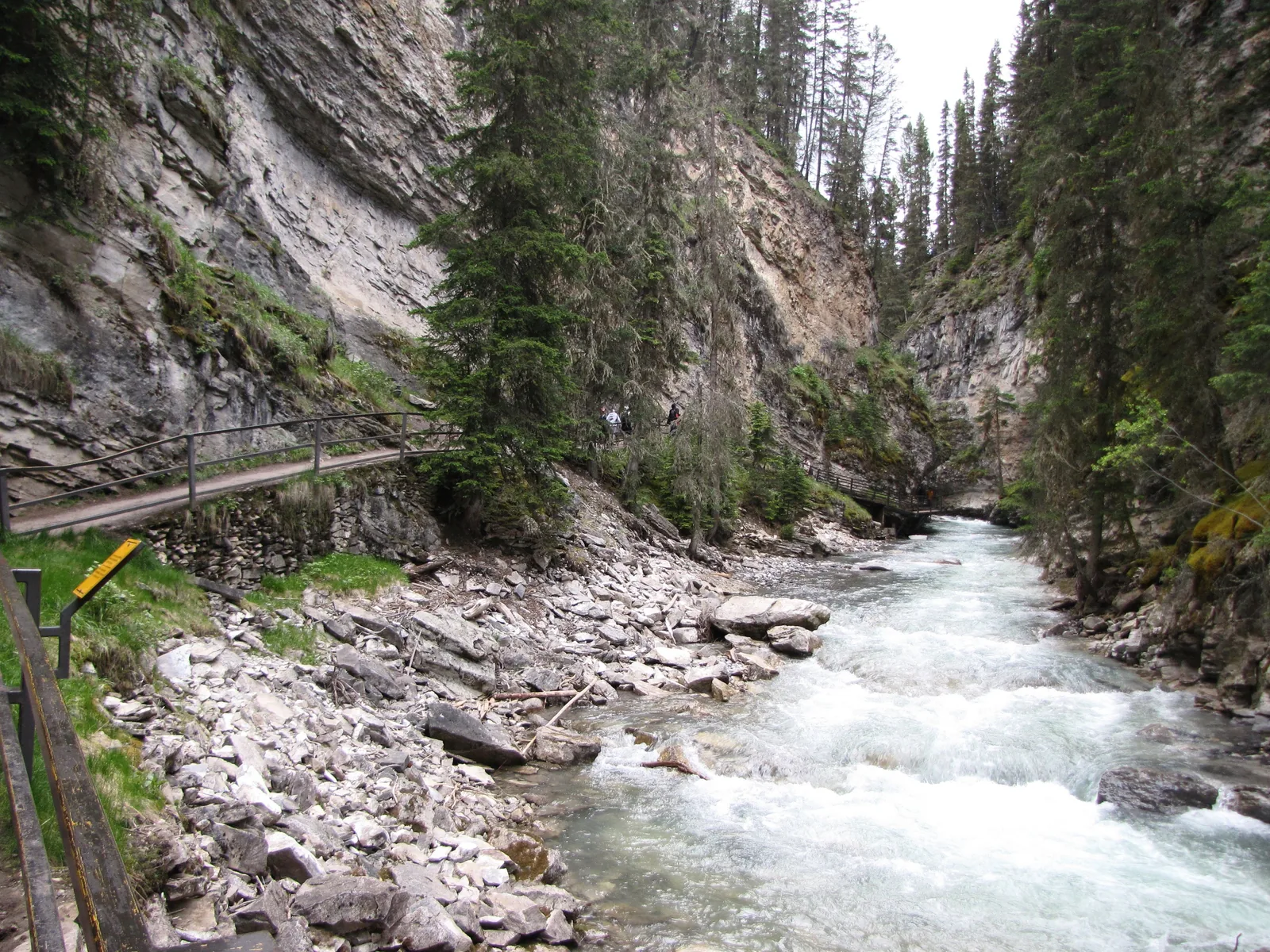 Holzsteg am Rand des Johnston Canyon über dem schäumenden Bach