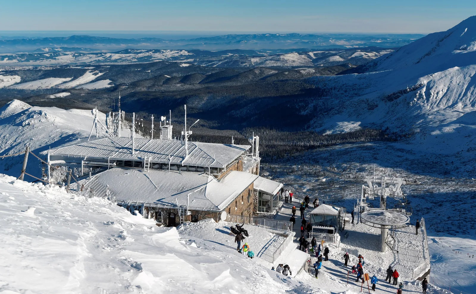 Die Bergstation der Seilbahn am Kasprowy Wierch im Winter, verschneite Hänge und Besucher, weiter Blick nach Norden