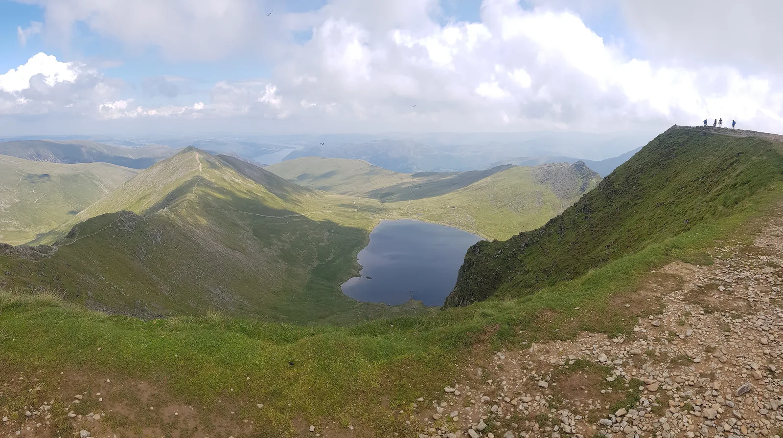 Blick vom Helvellyn im Lake-District-Nationalpark auf den Bergsee Red Tarn zwischen den Graten Swirral Edge und Striding Edge