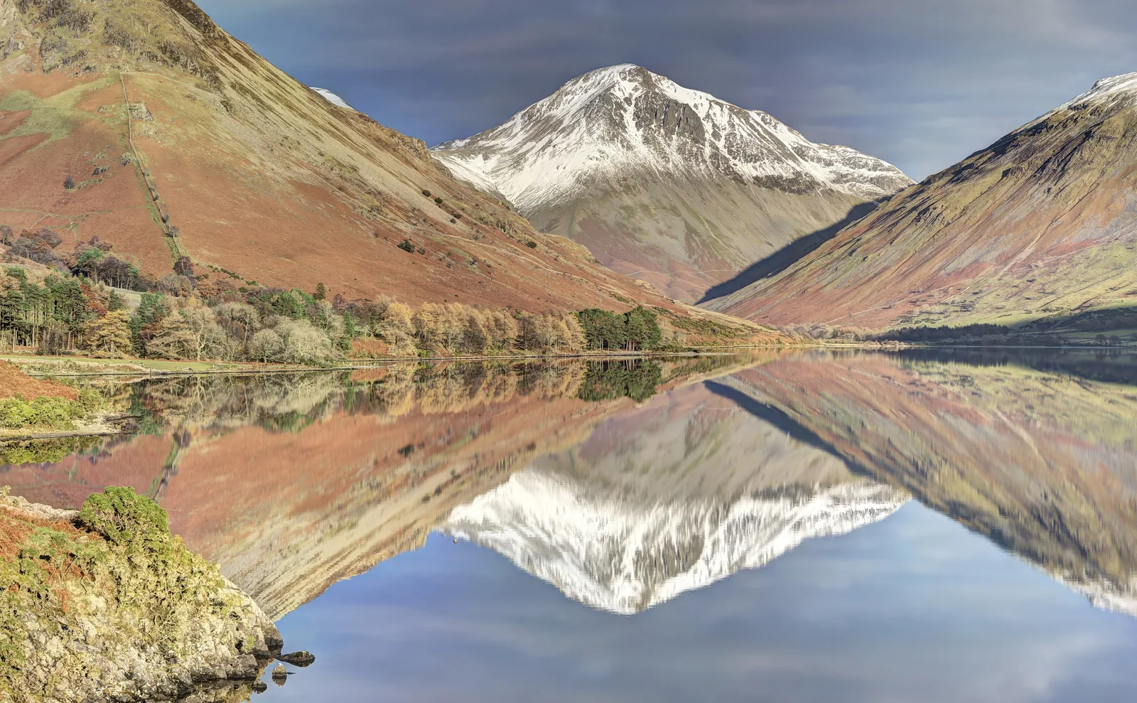 Wast Water im Lake-District-Nationalpark spiegelt die Berge bei Wasdale Head, in der Mitte der verschneite Gipfel des Great Gable