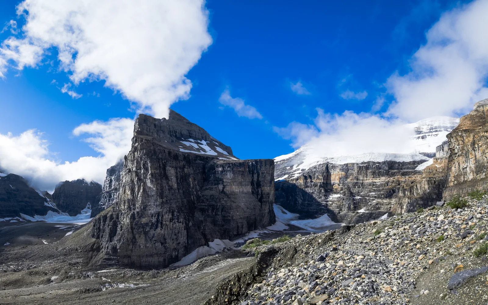 Geröll und Felsen an der Plain of Six Glaciers, dahinter Gletscher und Wolken