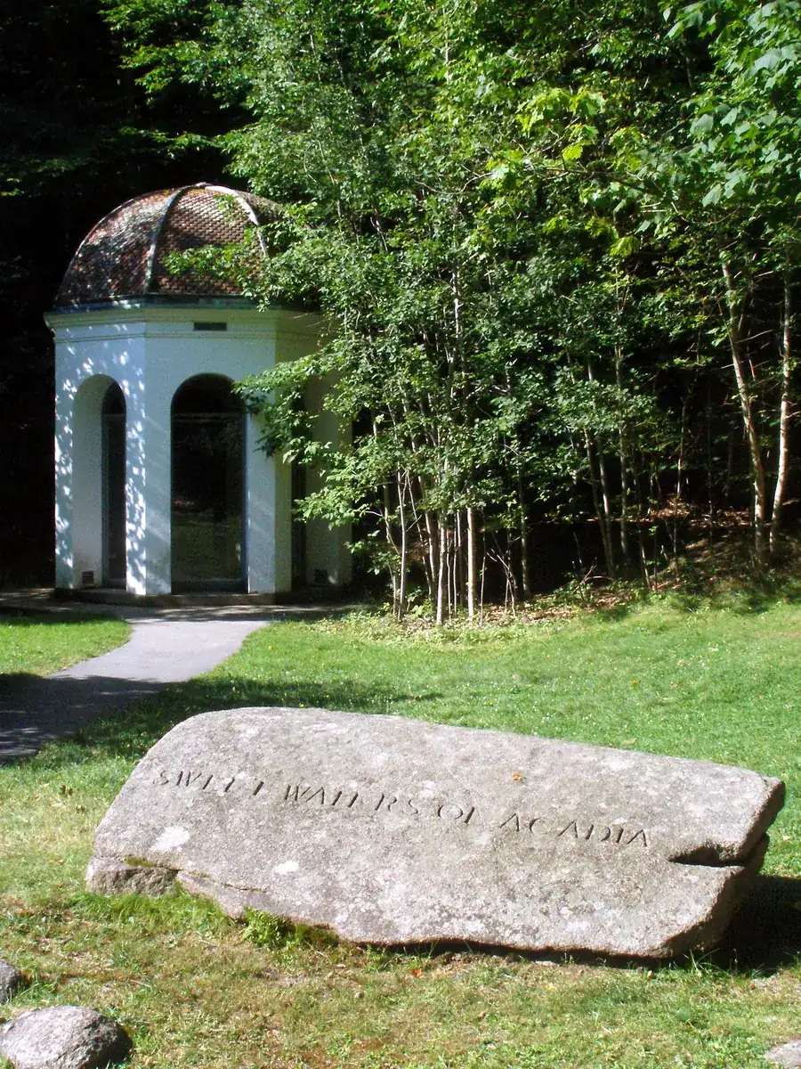 Kleines weißes Quellhaus über der Sieur-de-Monts-Quelle, davor ein Granitblock mit eingemeißelter Inschrift
