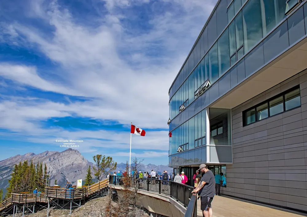 Moderne Bergstation der Banff Gondola auf dem Sulphur Mountain mit Holzstegen und Blick auf umliegende Gipfel