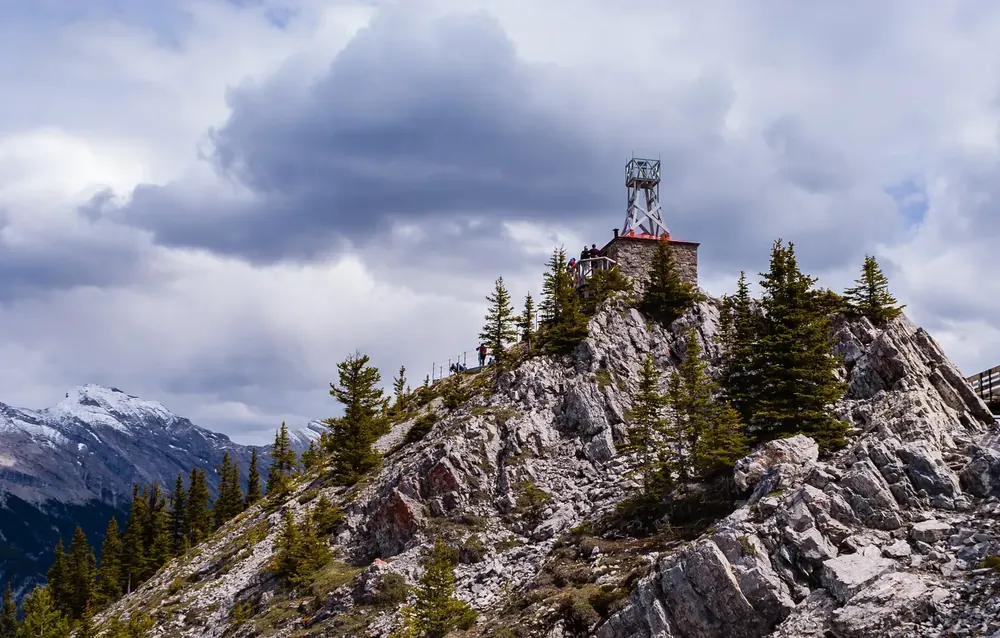 Gipfel des Sanson Peak auf dem Sulphur Mountain mit dem steinernen Observatorium der historischen Stätte, ringsum Felsen und Fichten