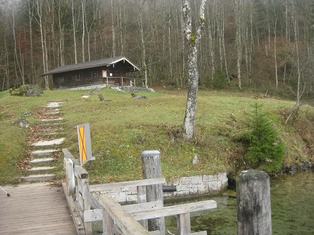 Bootshaltestelle Kessel am Ostufer des Königssees: hölzerner Steg, Steintreppe und Unterstandshütte zwischen kahlen Bäumen