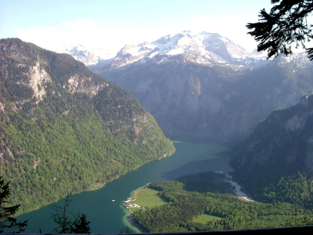 Blick von der Kührointalm hinab auf den Königssee zwischen steilen Bergflanken, dahinter Gletscherberge