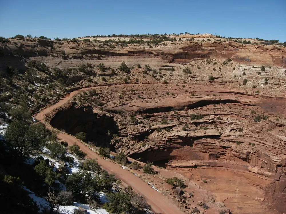 Blick vom Shafer Canyon Overlook auf die Serpentinen des Shafer Trail zwischen roten Felsstufen