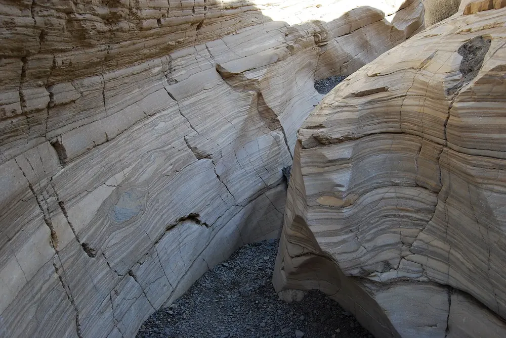 Mosaic Canyon: glatt geschliffene, marmorierte Felswände aus hellem Gestein an einer engen Schluchtstelle