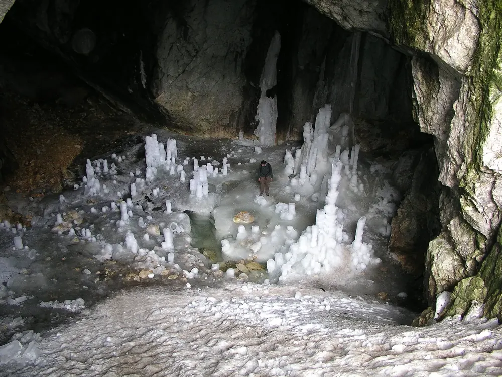 Ledena pećina: Eissäulen und Eisstalagmiten im Inneren der Eishöhle, am Boden eine Schicht aus Eis