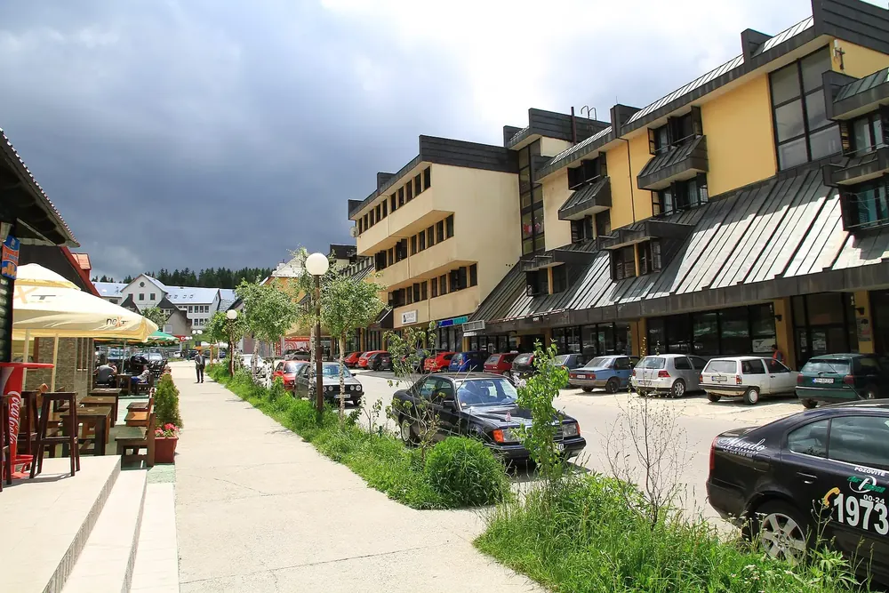 Hauptstraße von Žabljak: Geschäftszeile mit Cafés und Parkplätzen unter bewölktem Himmel