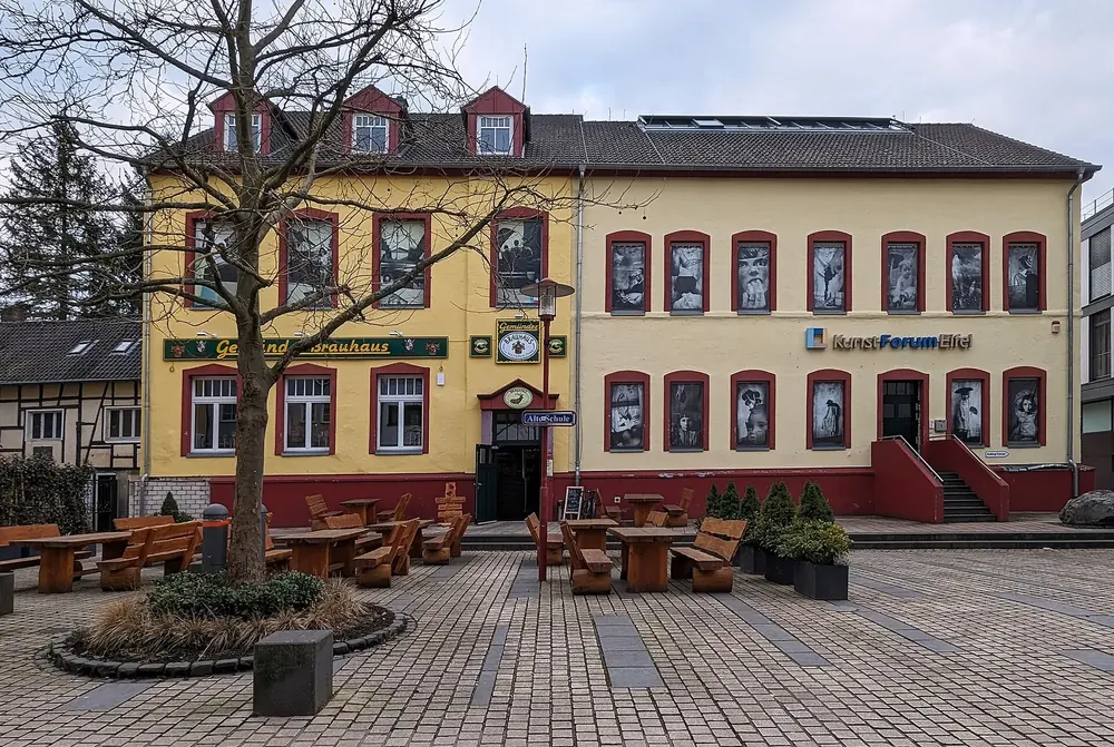 Gebäude des KunstForum Eifel an der Dreiborner Straße in Schleiden-Gemünd, davor ein gepflasterter Platz