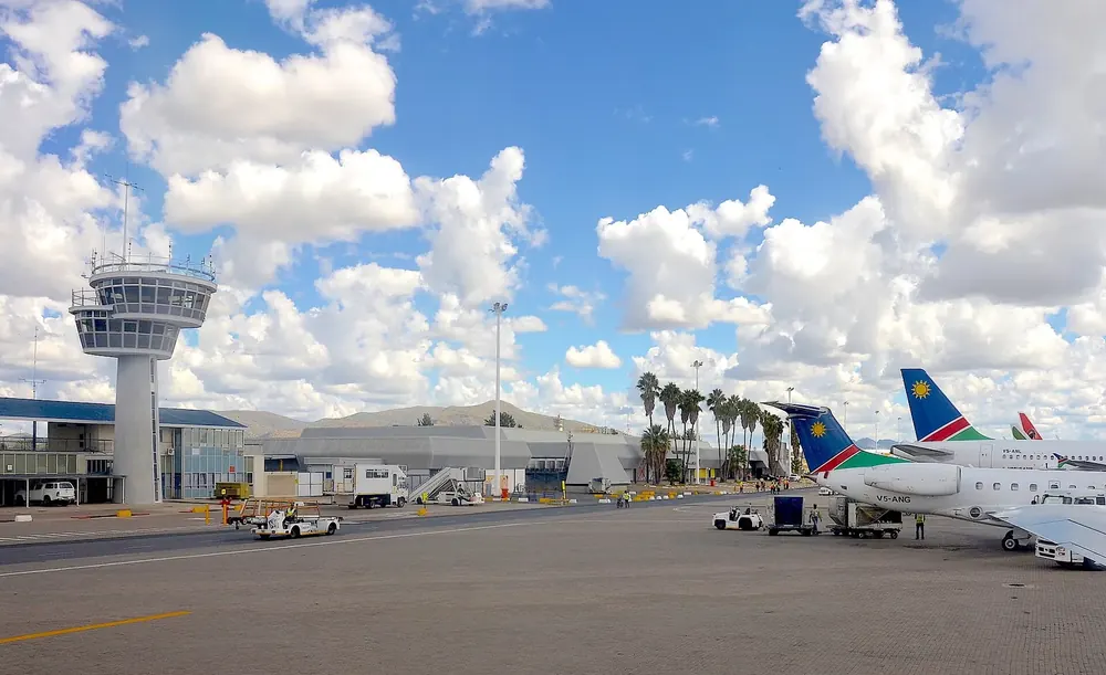 Hosea Kutako International Airport: Kontrollturm, Terminal und Flugzeuge auf dem Vorfeld unter Quellwolken