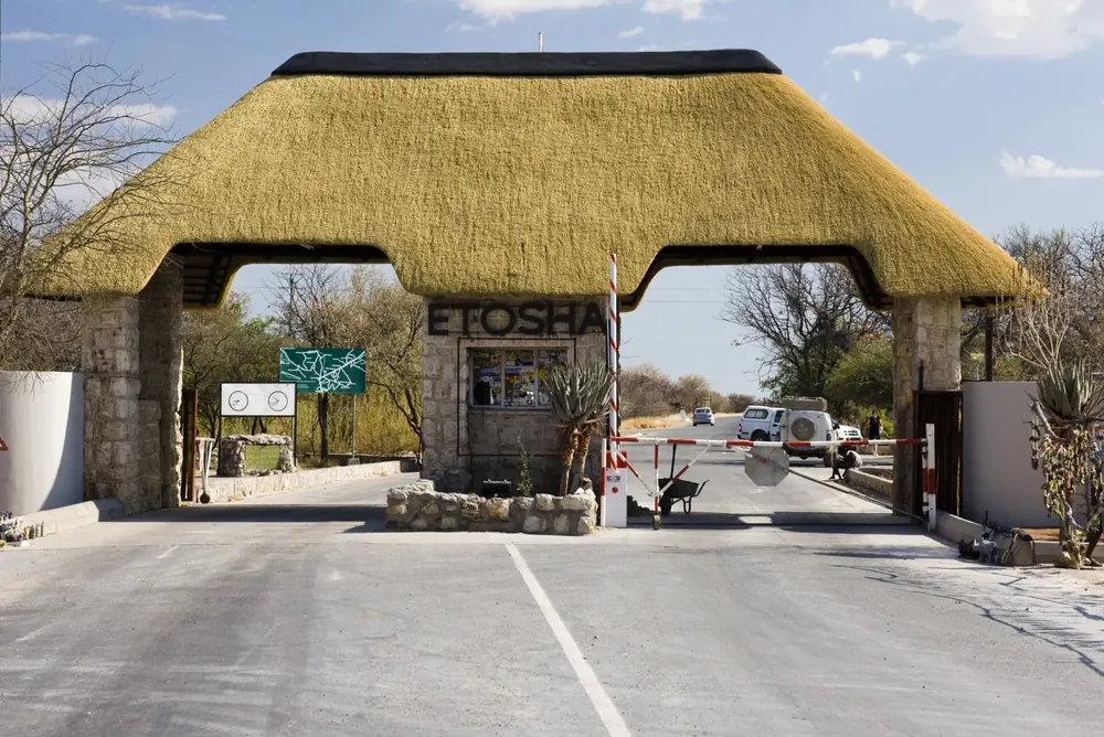 Andersson Gate, das südliche Eingangstor zum Etosha-Nationalpark, mit großem Reetdach über der Zufahrt