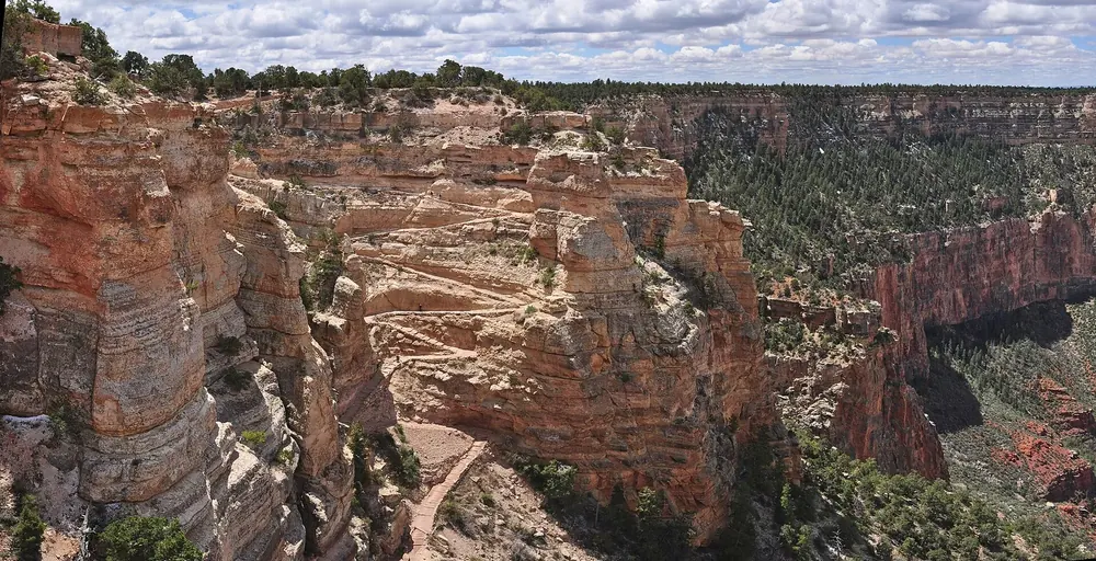 Beginn des South Kaibab Trail: Serpentinen an der Felswand, dahinter tief eingeschnittene Canyons unter Wolken