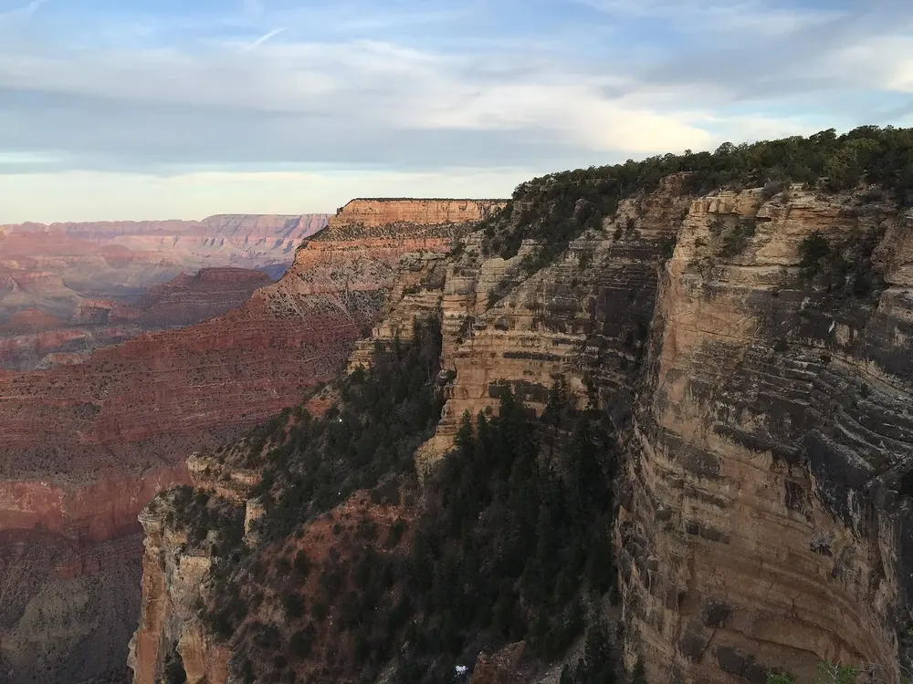 Blick vom Yavapai Point nach Osten über gestufte Felswände und Schluchten des Grand Canyon im Abendlicht