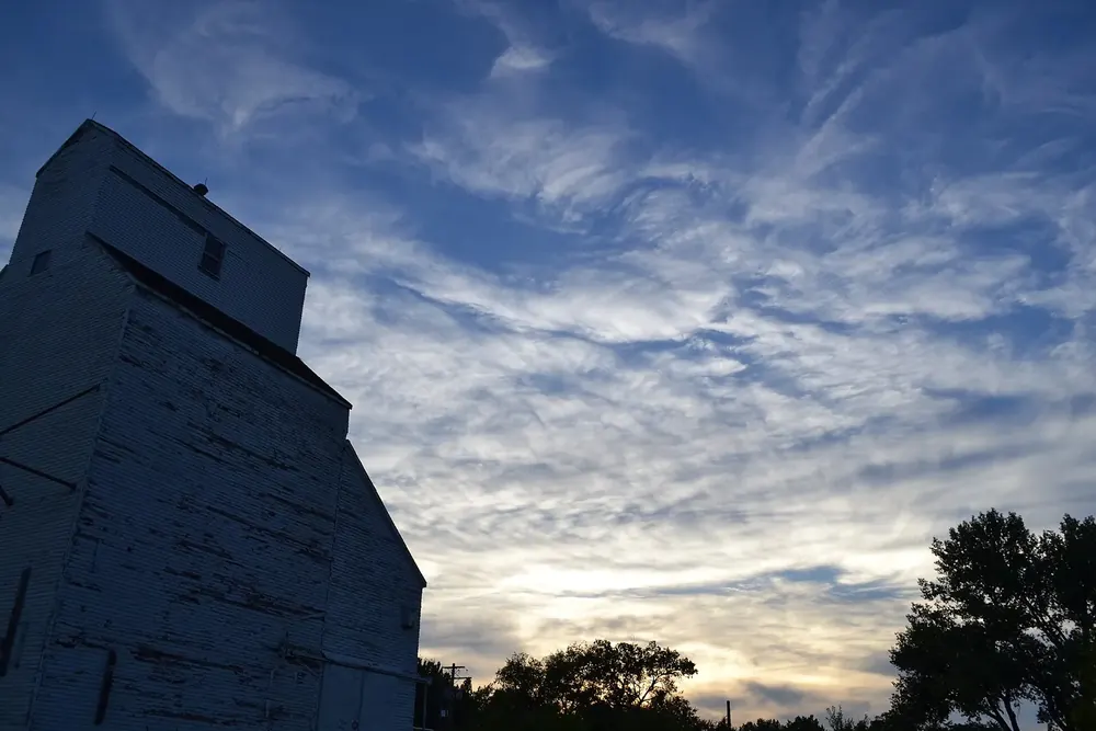 Der alte Getreidesilo von Val Marie als dunkle Silhouette vor bewegtem Abendhimmel mit Schleierwolken