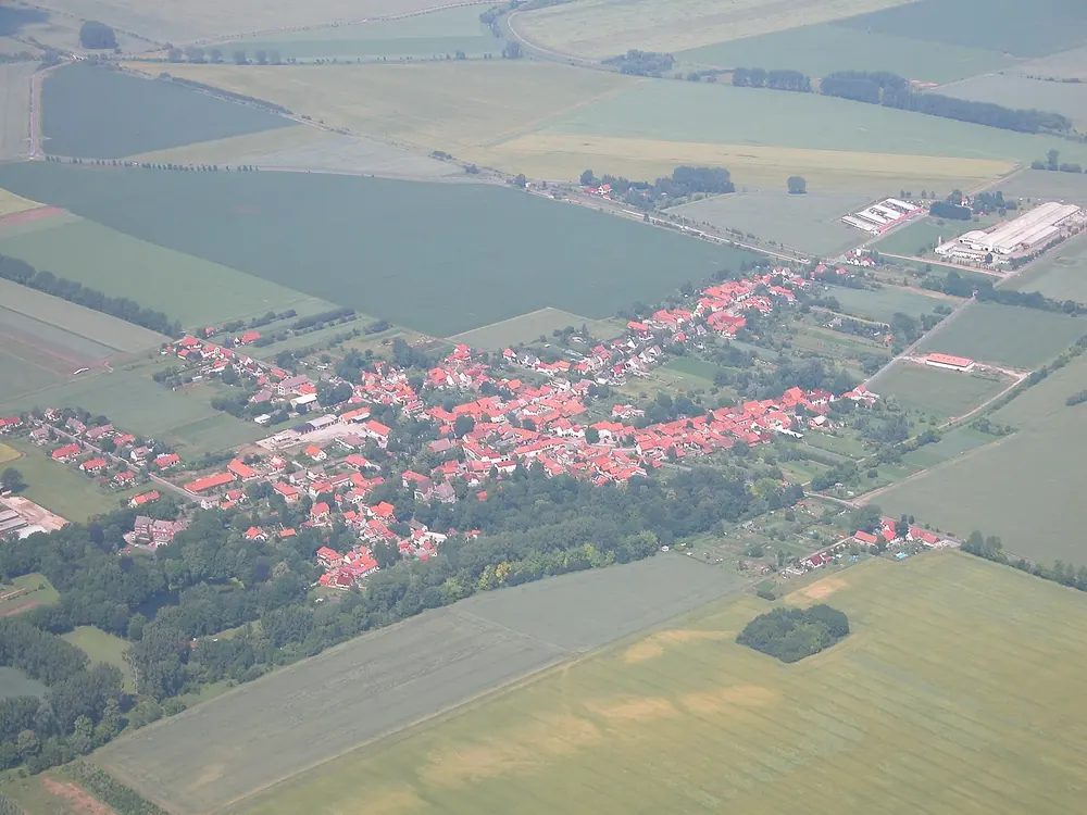Blick über Seebach: Dorf mit roten Dächern inmitten weiter Felder und Wiesen