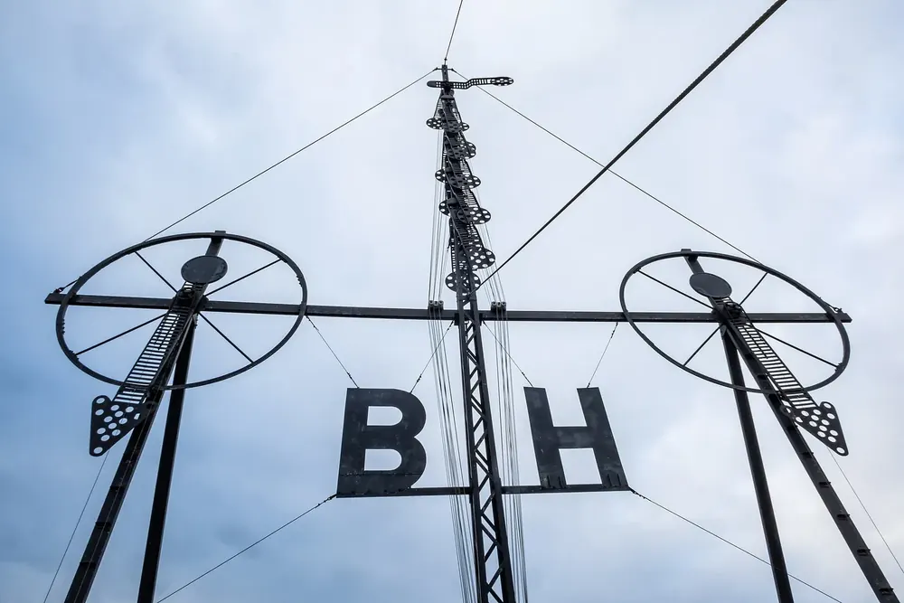 Historischer Semaphor in Cuxhaven: Signalmast mit Windzeigern und den Buchstaben B und H vor grauem Himmel