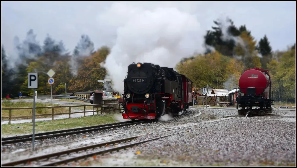 Dampflok der Harzer Schmalspurbahnen mit Kesselwagen im Bahnhof Drei Annen Hohne, dahinter herbstlicher Wald