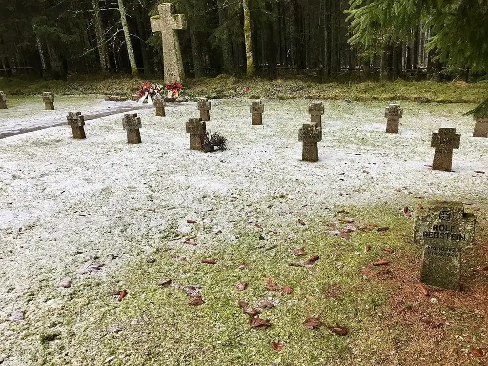 Ehrenfriedhof Oderbrück: steinerne Grabkreuze auf einer mit Schnee bestäubten Lichtung im Fichtenwald
