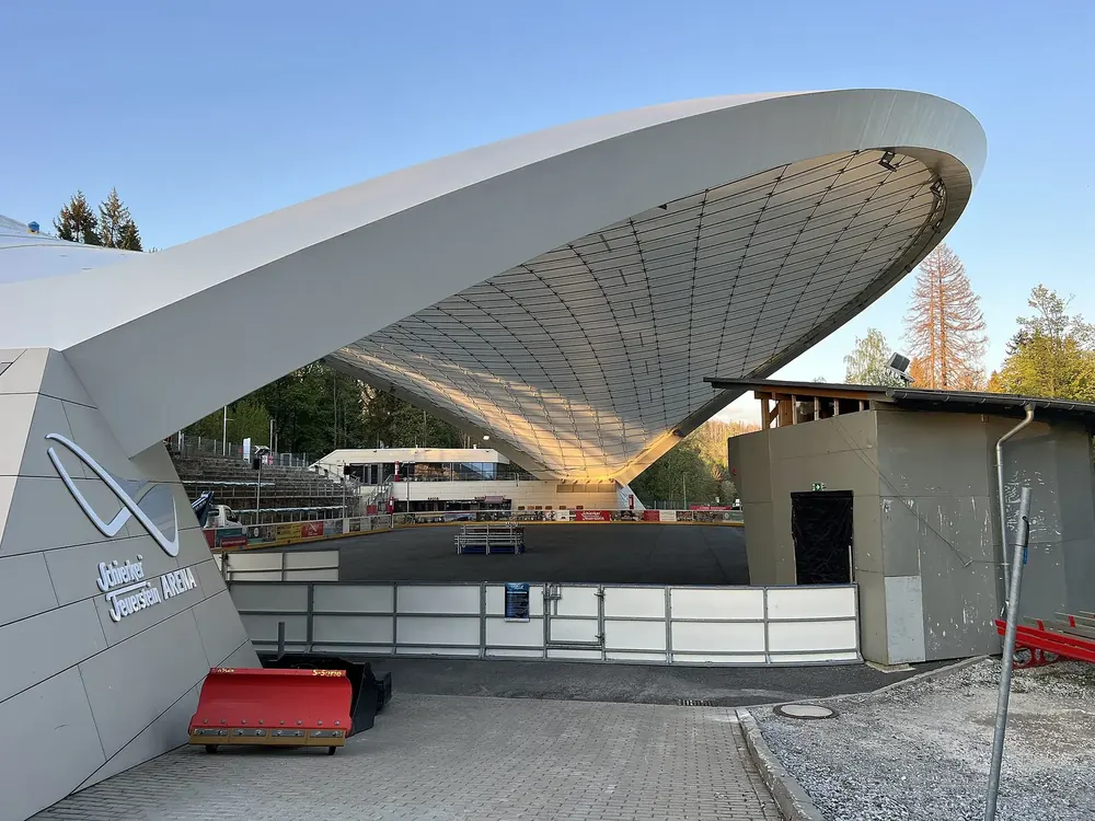Schierker Feuerstein Arena: weiß geschwungenes Dach über der Eis- und Veranstaltungsfläche, daneben ein Flachbau