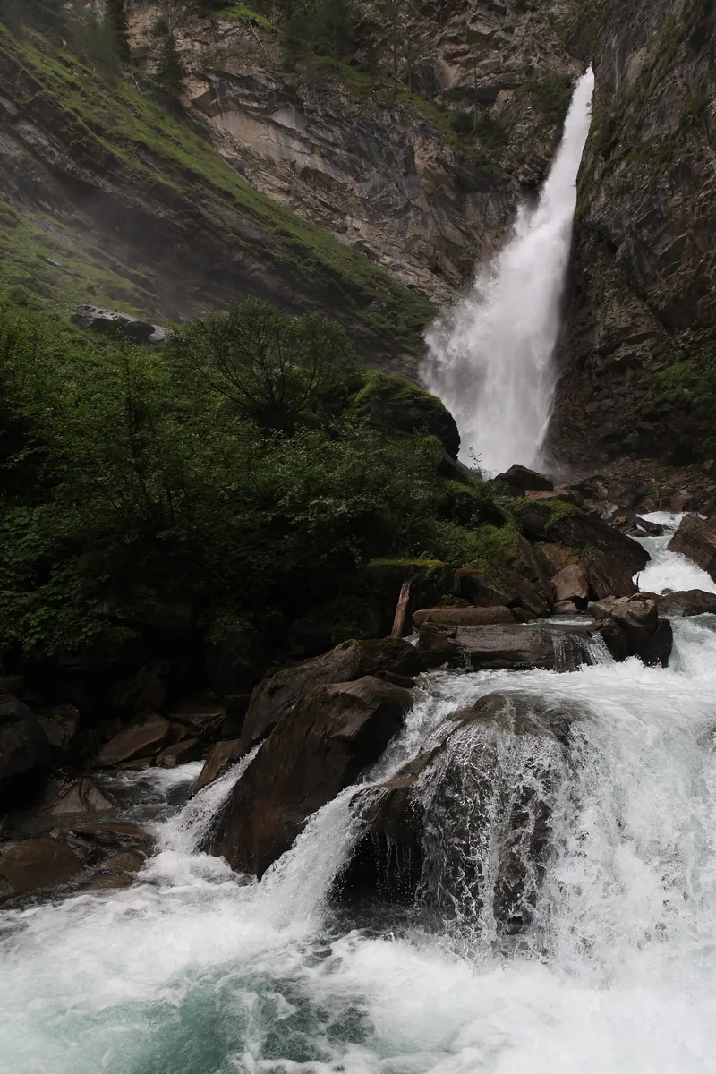 Gößnitzfall: hoher Wasserfall stürzt über eine Felswand, darunter schäumende Kaskaden zwischen Felsblöcken
