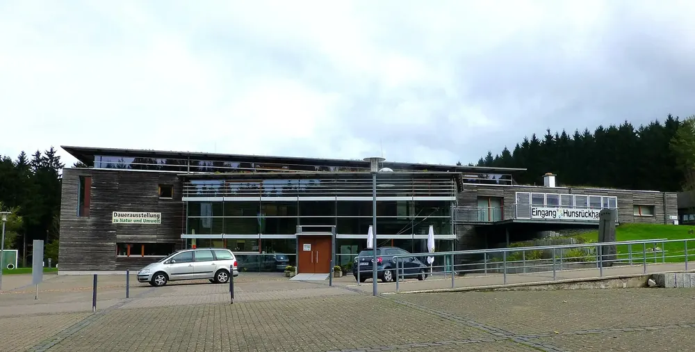 Hunsrückhaus am Erbeskopf: moderner Bau mit Holzfassade und Glasfront am Nationalpark-Tor, davor ein Parkplatz