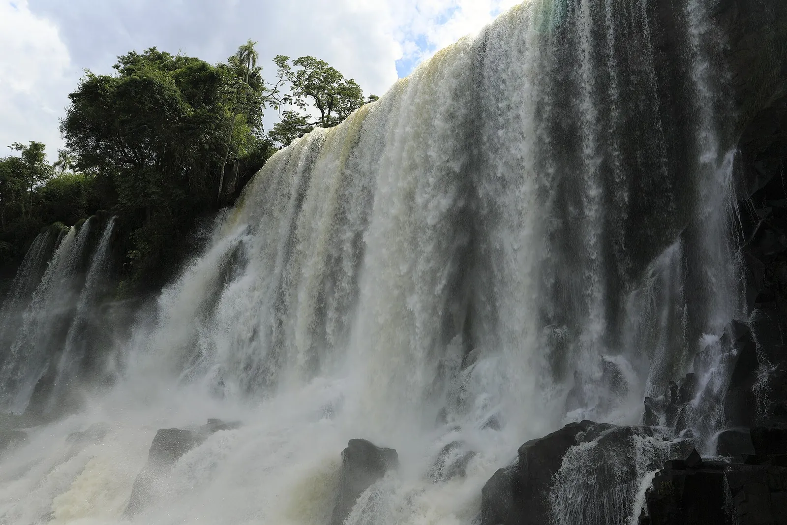 Der Salto Bossetti im Iguazú-Nationalpark aus der Nähe vom unteren Rundweg: breiter Wasservorhang über dunklen Basaltfelsen, oben Regenwald