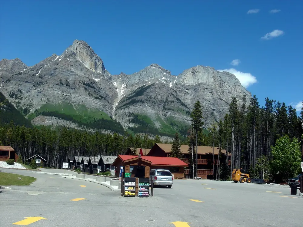 Saskatchewan River Crossing: Rasthof mit roten Dächern, Zapfsäulen und Parkplatz vor schroffen Kalkgipfeln